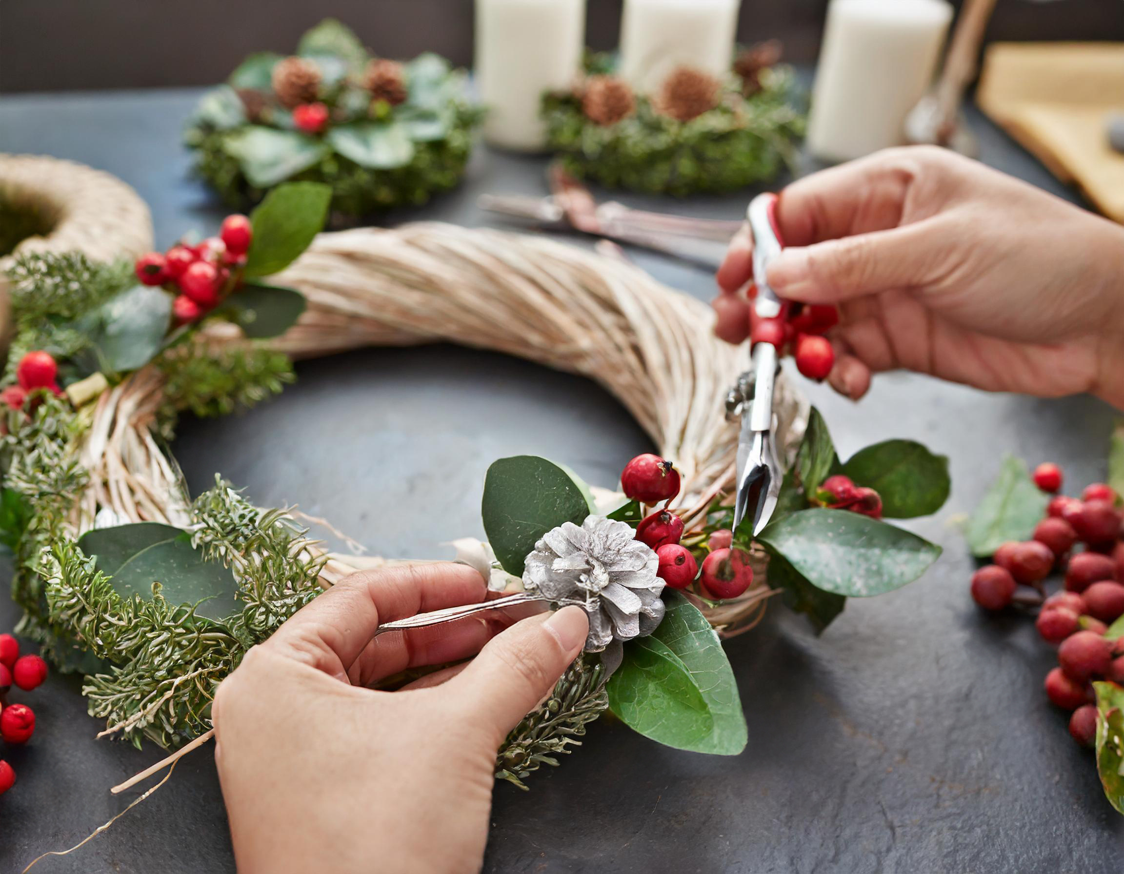 Pracownik produkcji przy produkcji wianków świątecznych